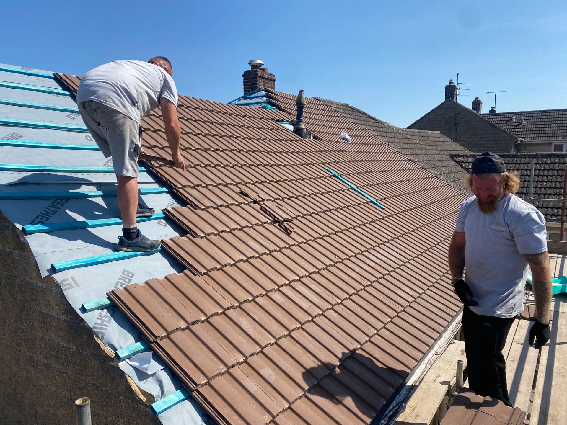 New interlocking roof tiles being laid during a complete re-roof in Gloucestershire