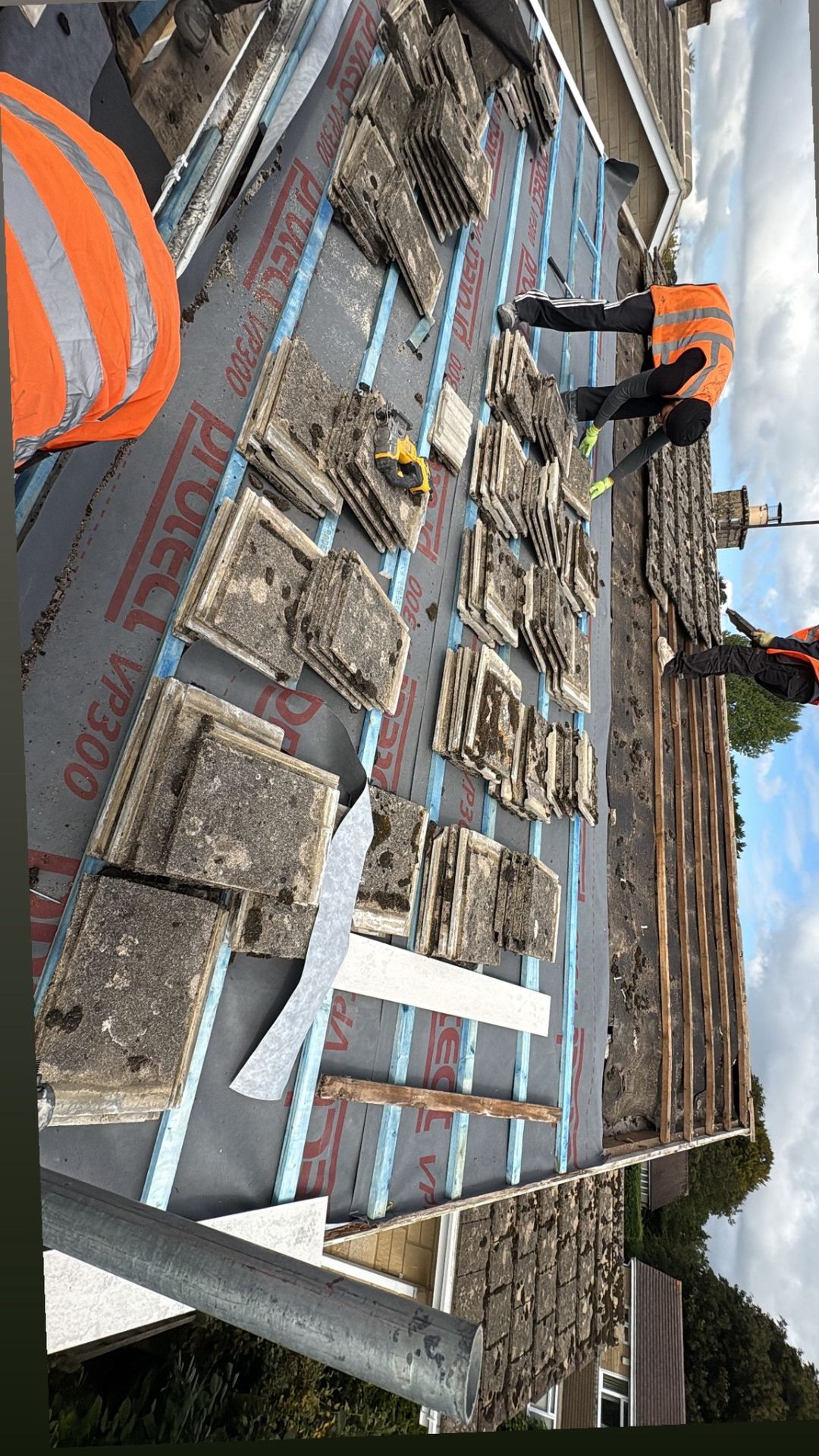 Roof tiles being sorted and laid on new membrane during a residential re-roofing project